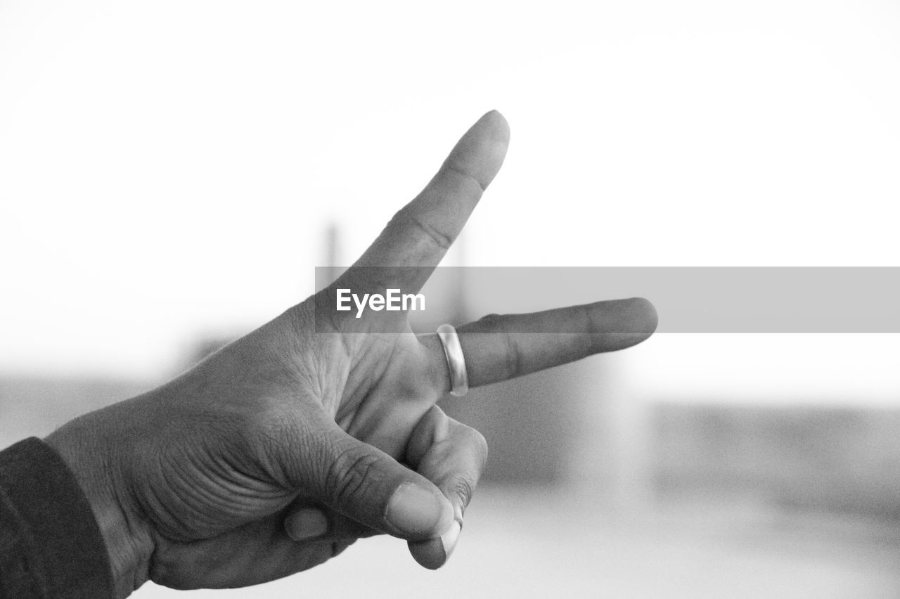 Cropped hand of man showing peace sign