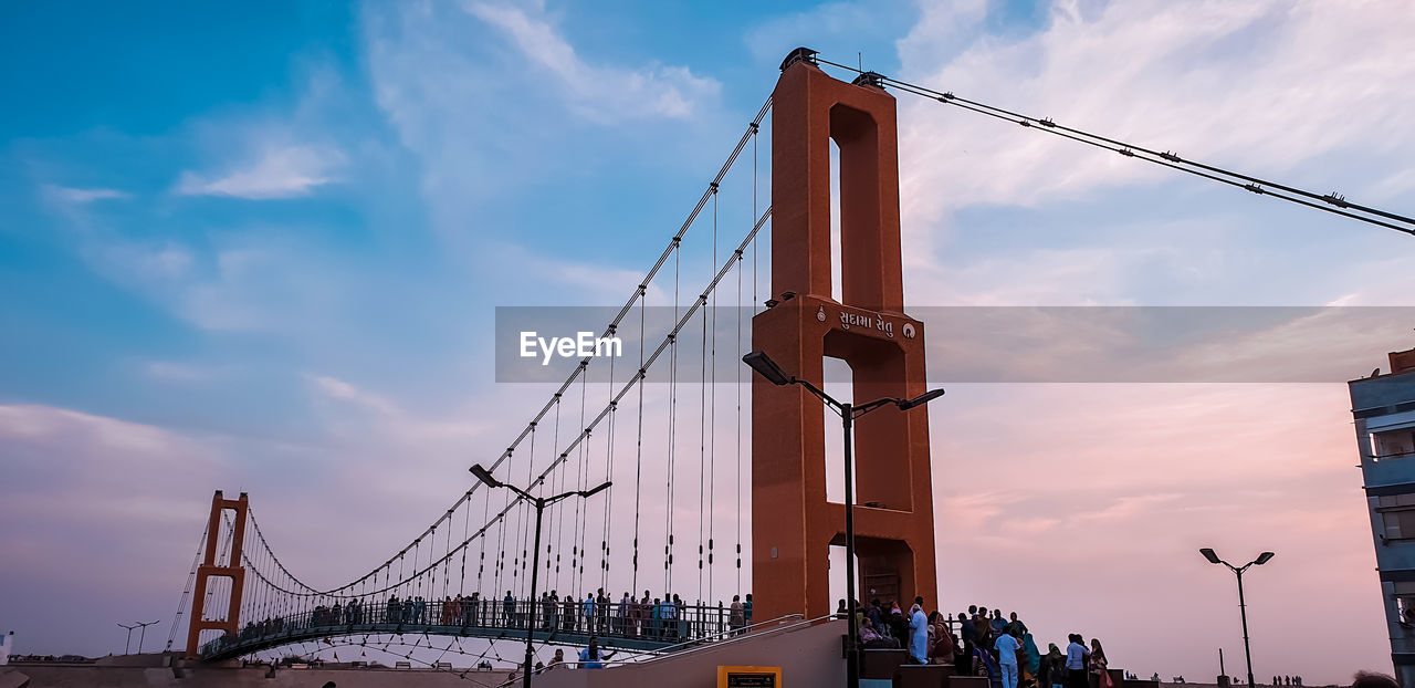 Low angle view of bridge against cloudy sky