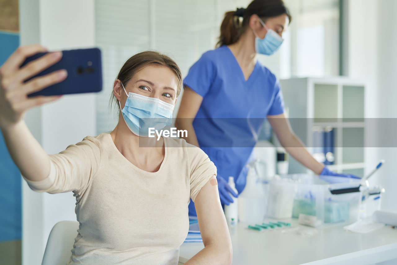 Woman wearing mask talking selfie at hospital