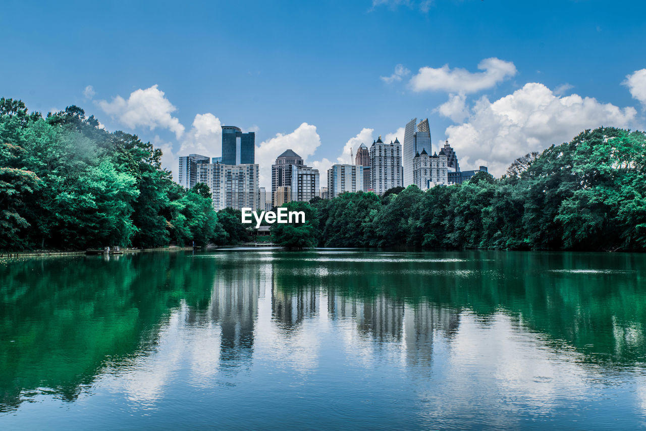 Reflection of buildings in lake against sky