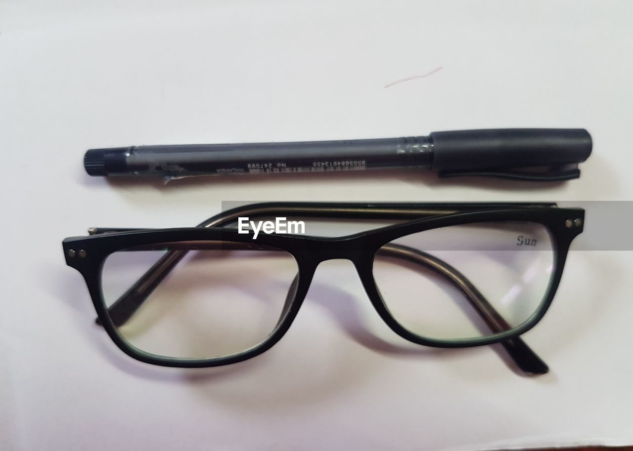 CLOSE-UP OF EYEGLASSES ON WHITE TABLE