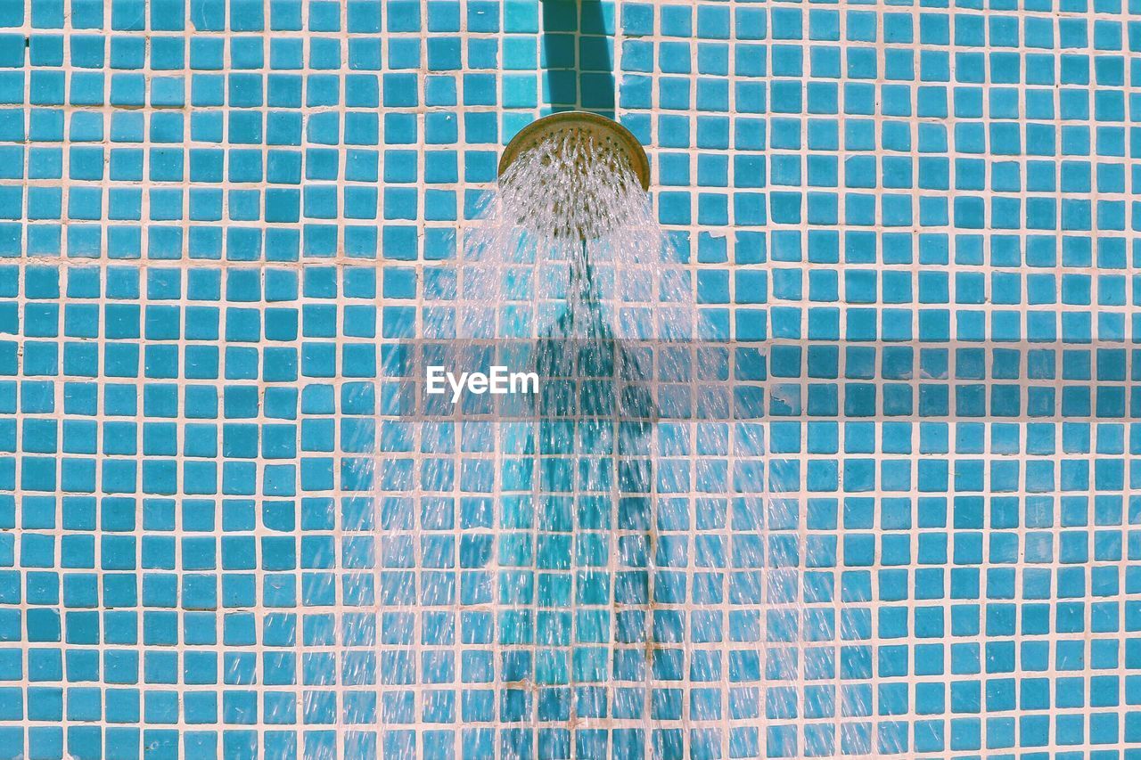 Close-up of water running from shower head in bathroom