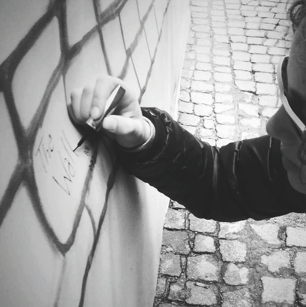 CLOSE-UP OF WOMAN STANDING AGAINST WHITE WALL