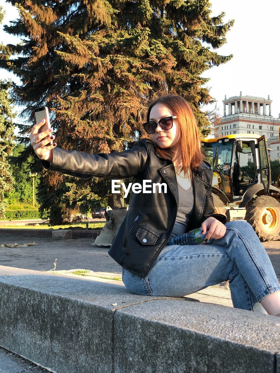 YOUNG WOMAN SITTING ON CAR