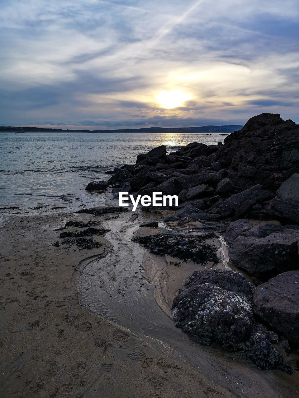 SCENIC VIEW OF ROCKS ON BEACH AGAINST SKY