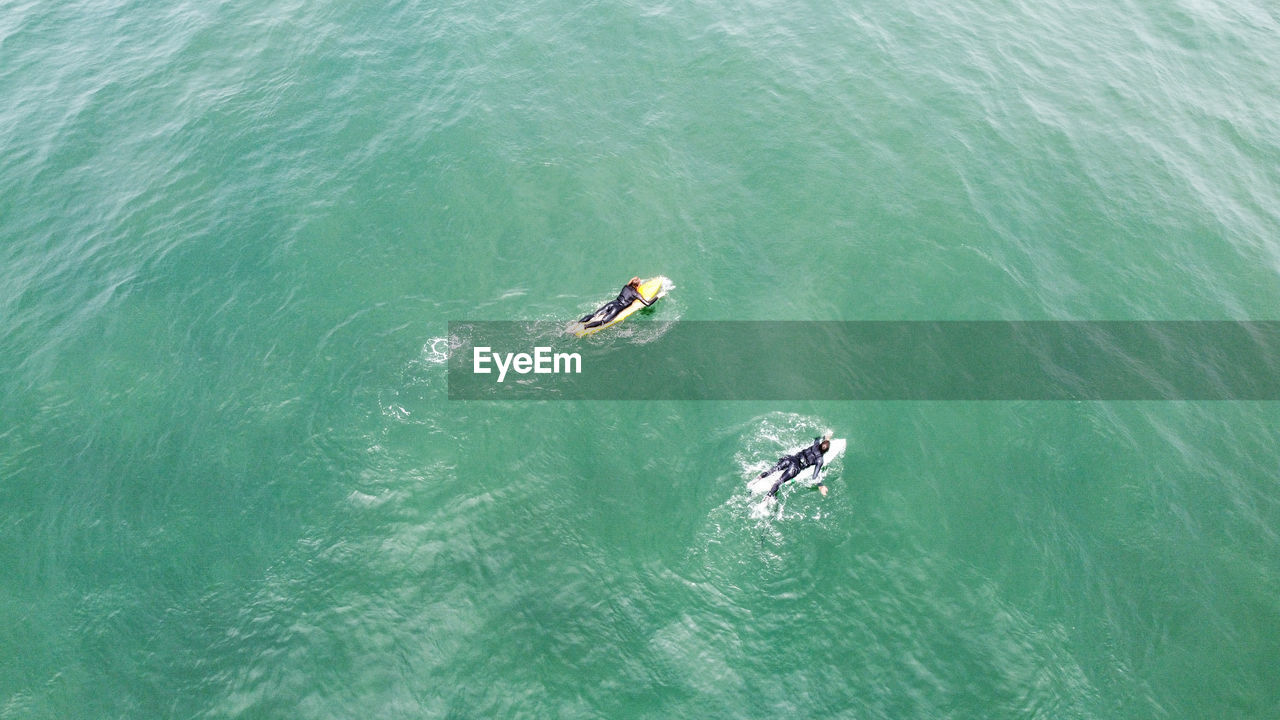 HIGH ANGLE VIEW OF PEOPLE ENJOYING IN SEA