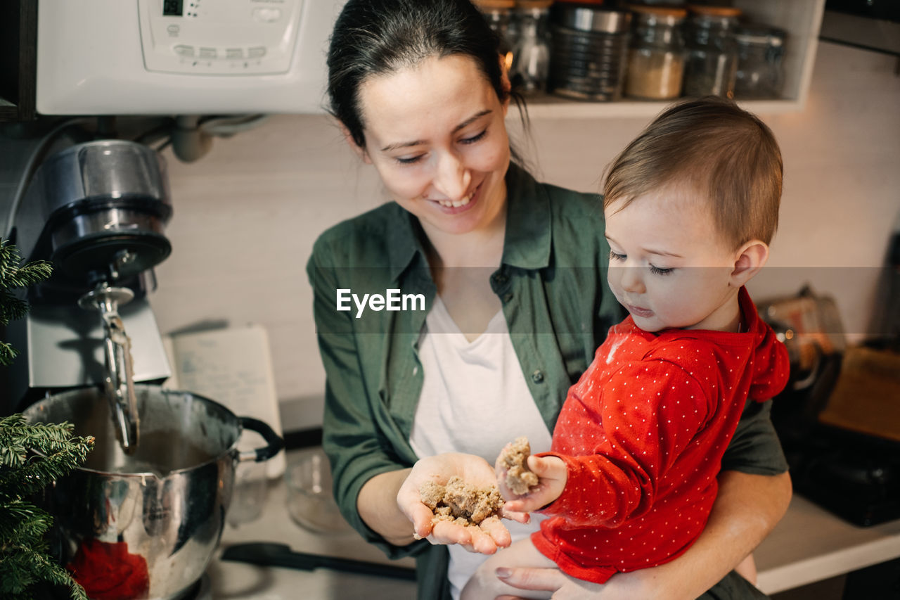 Cozy christmas at home. family preparation holiday dessert. mother and baby toddler daughter play