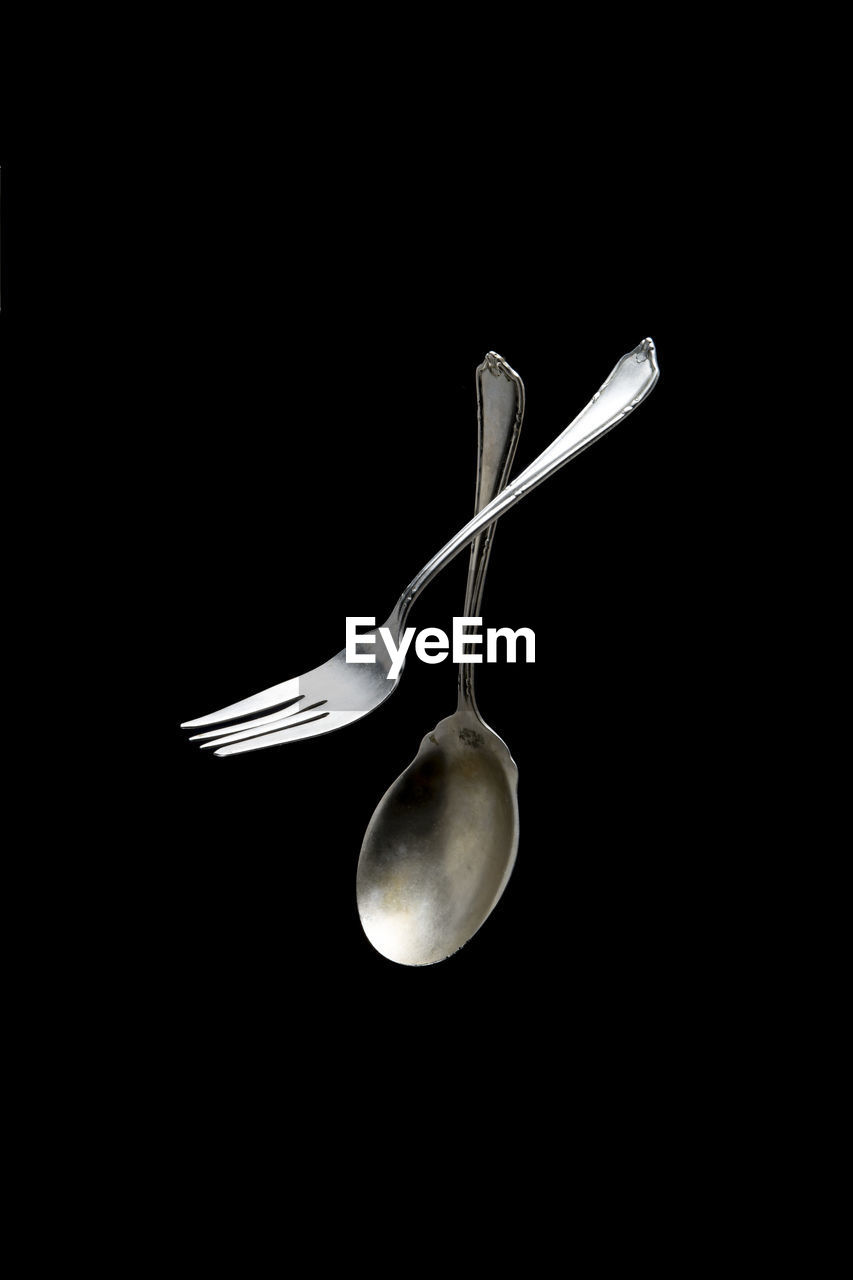 Fork and spoon against black background