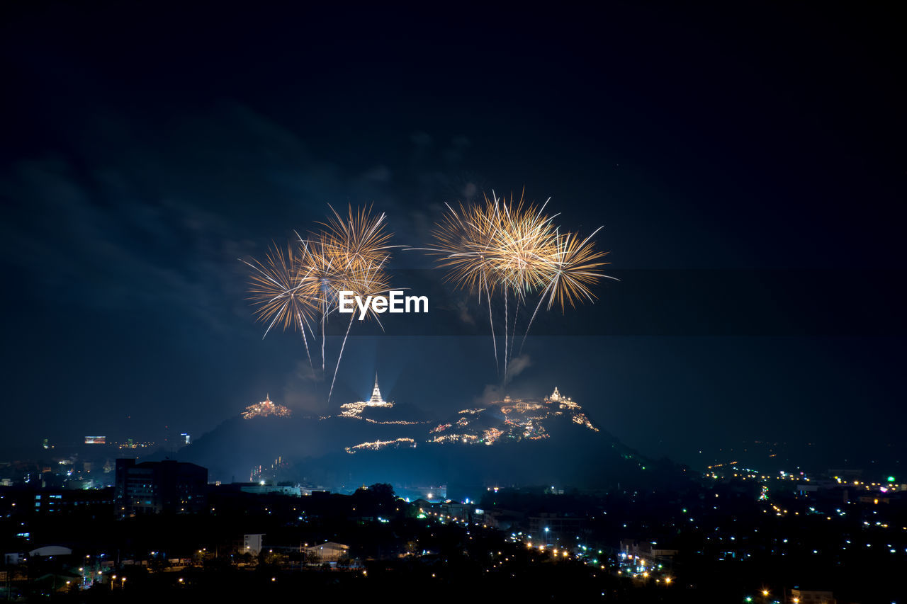 Firework display over cityscape at night