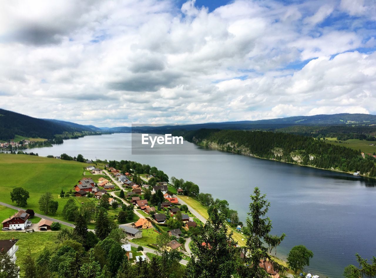 VIEW OF CALM LAKE AGAINST CLOUDY SKY