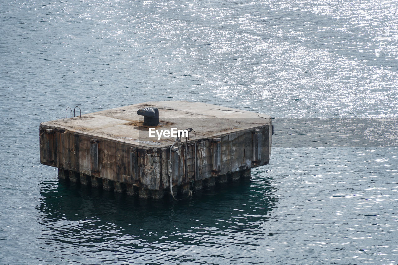 HIGH ANGLE VIEW OF BIRDS PERCHING ON SEA