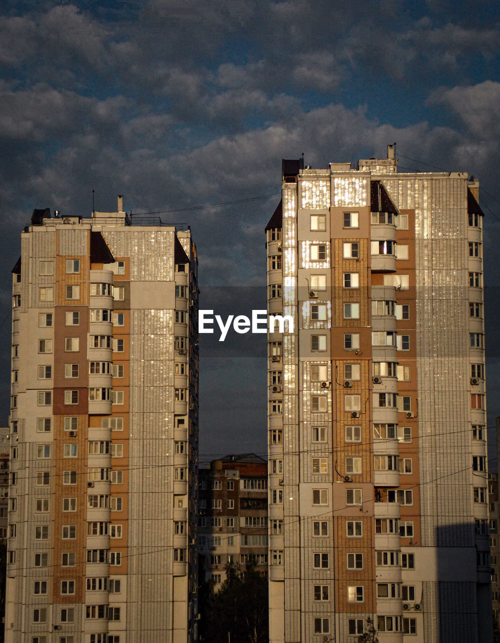 Low angle view of buildings against cloudy sky