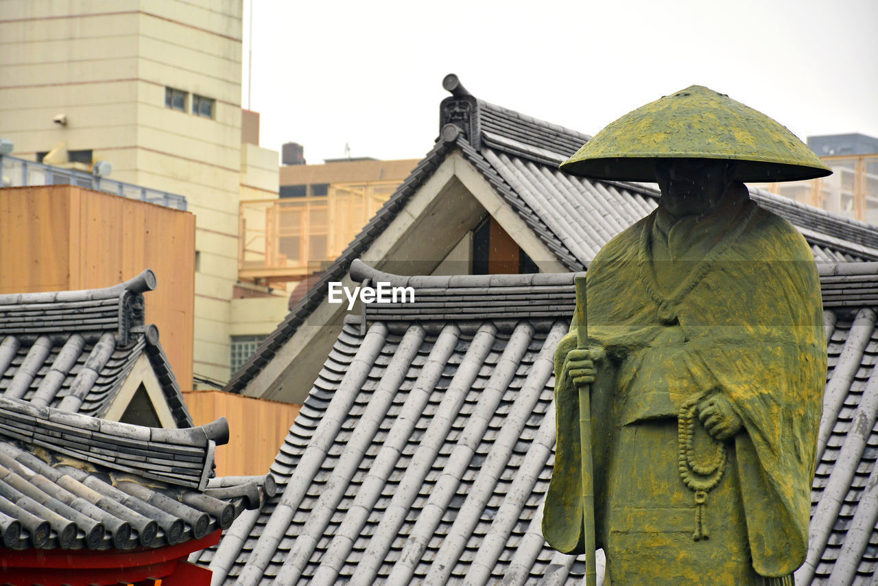 LOW ANGLE VIEW OF SCULPTURE OUTSIDE BUILDING