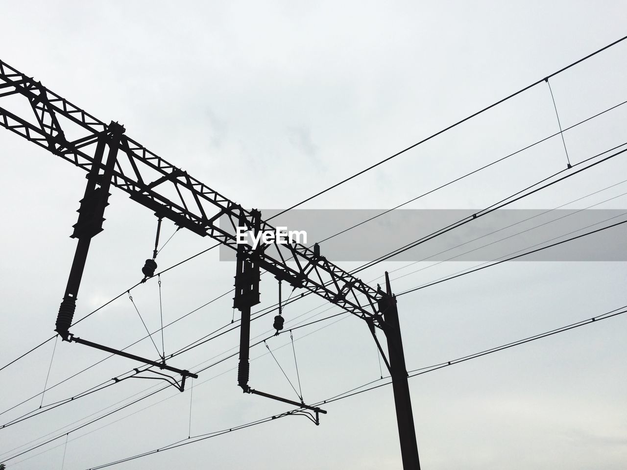 Low angle view of silhouette power lines against sky at dusk