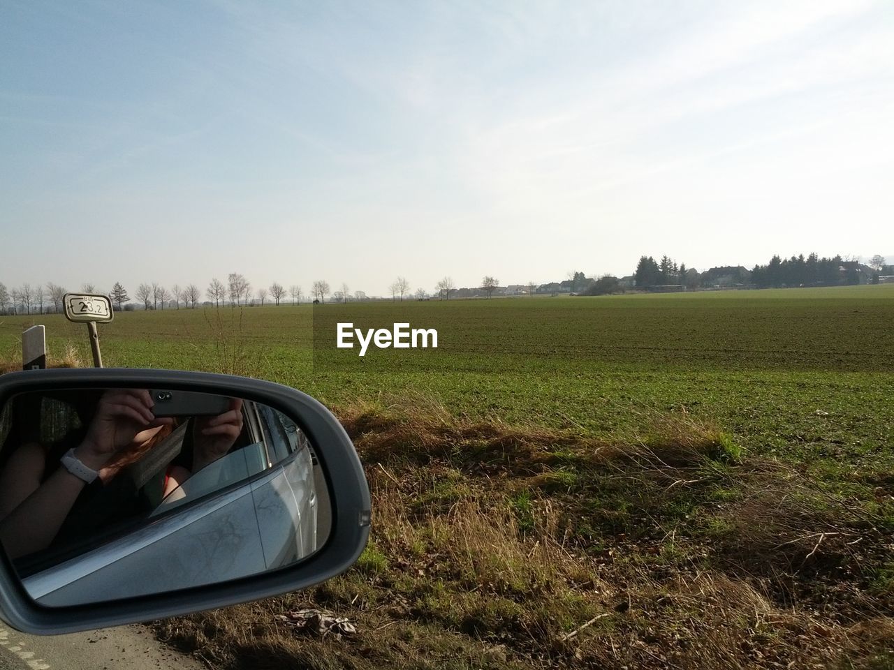 Reflection of woman on side-view mirror photographing field