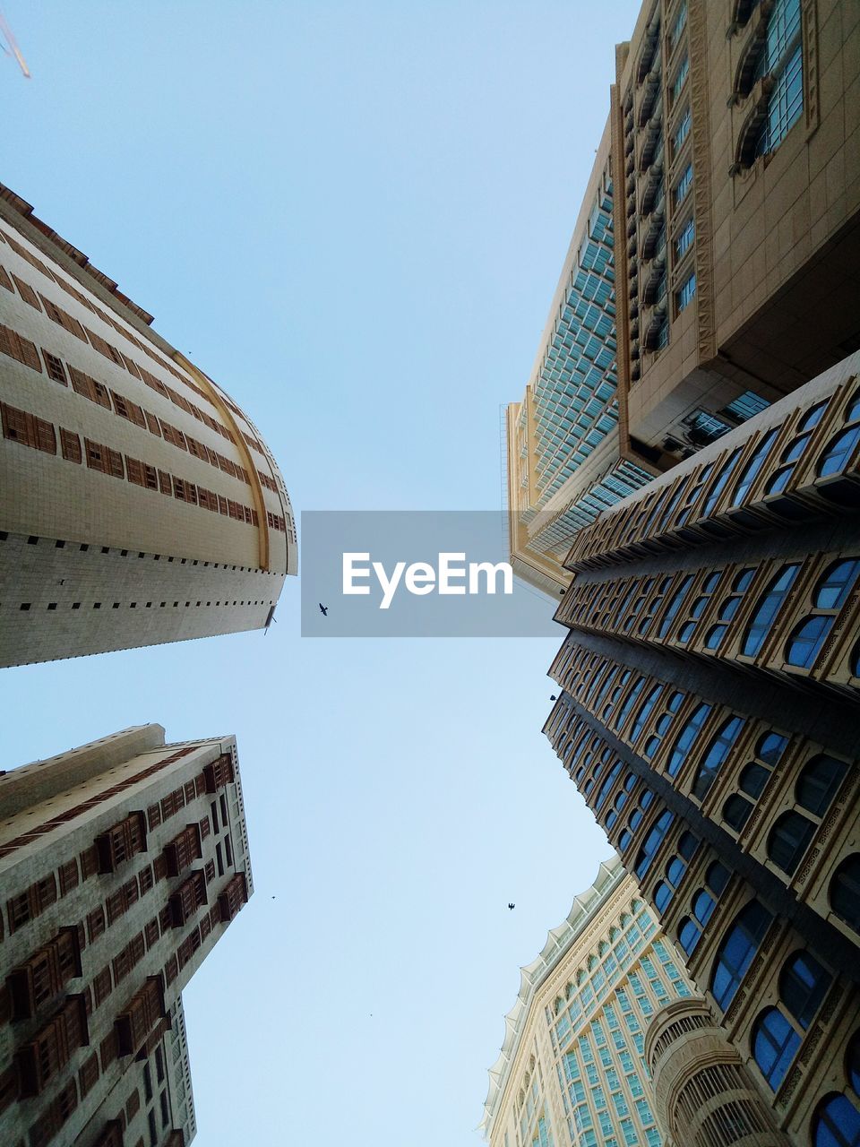 LOW ANGLE VIEW OF BUILDINGS IN CITY AGAINST CLEAR SKY