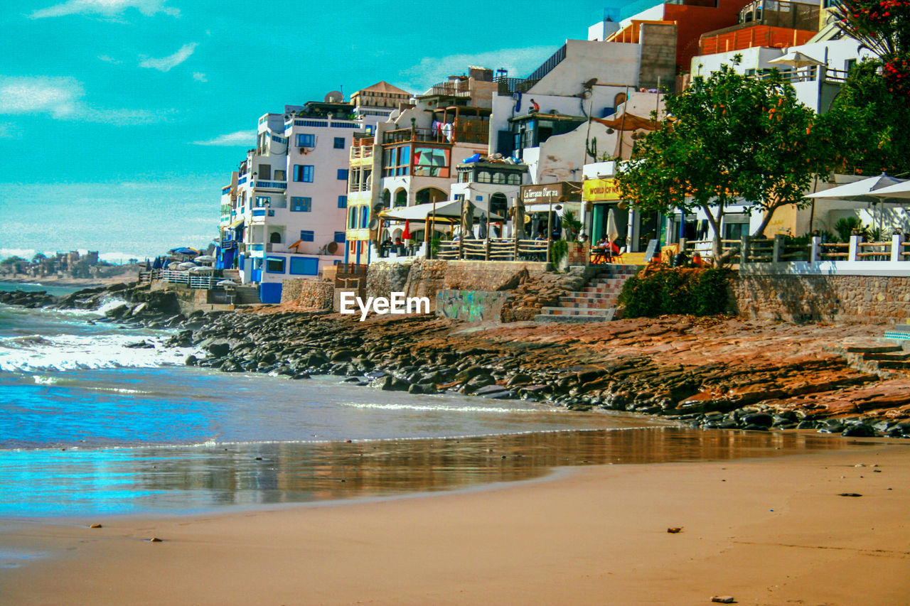 SCENIC VIEW OF SEA AGAINST BUILDINGS IN CITY