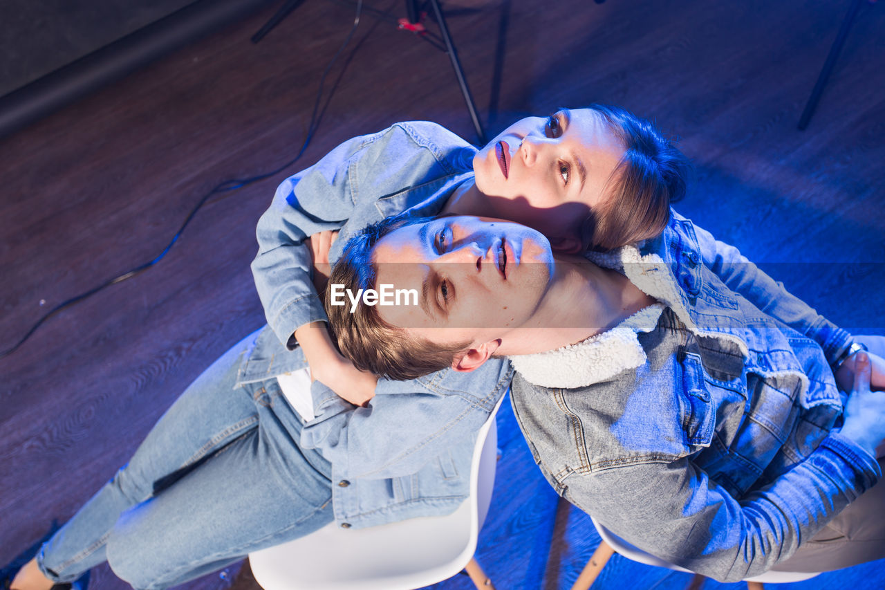 High angle view of mother and daughter against blue wall