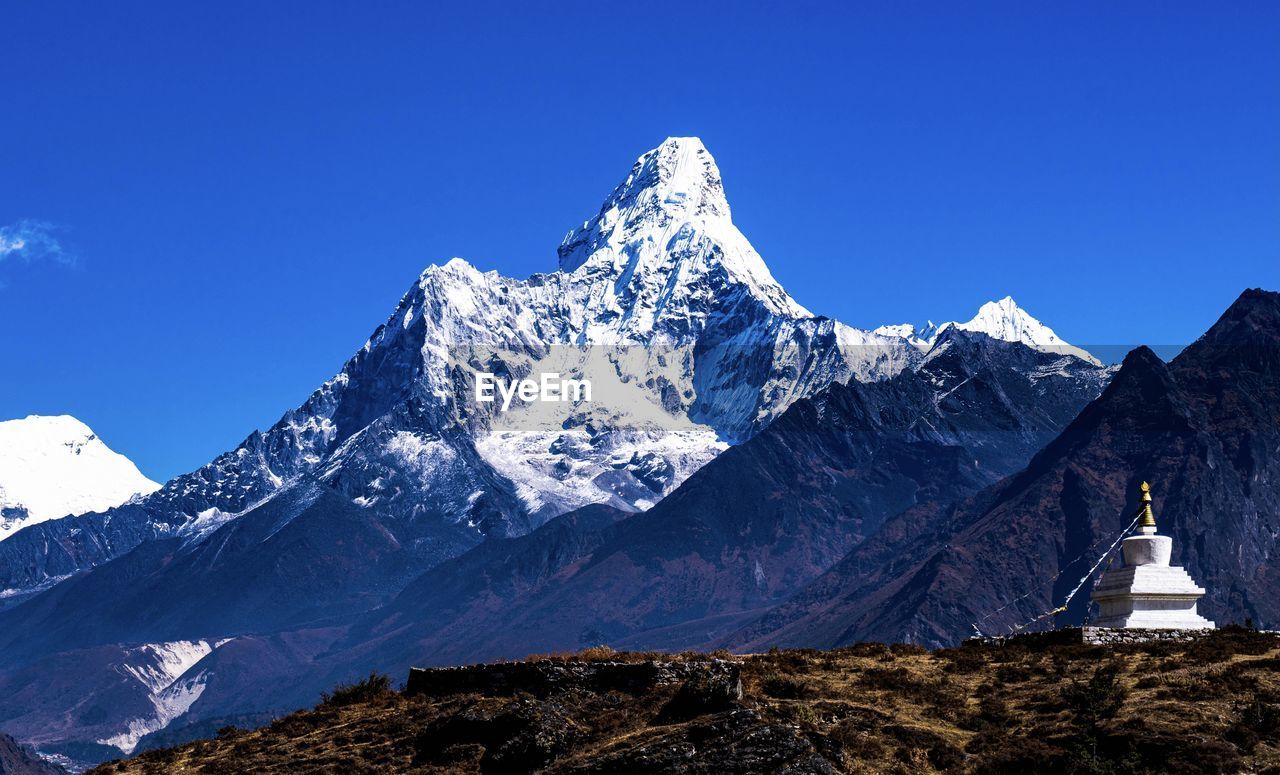 Scenic view of snowcapped mountains with nepali symbolic sculpture