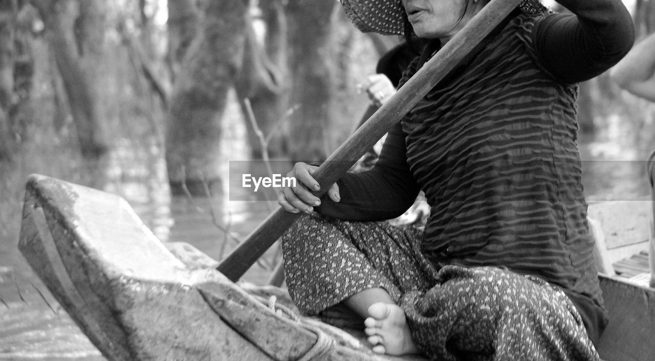 MIDSECTION OF MAN SITTING IN TRADITIONAL CLOTHING