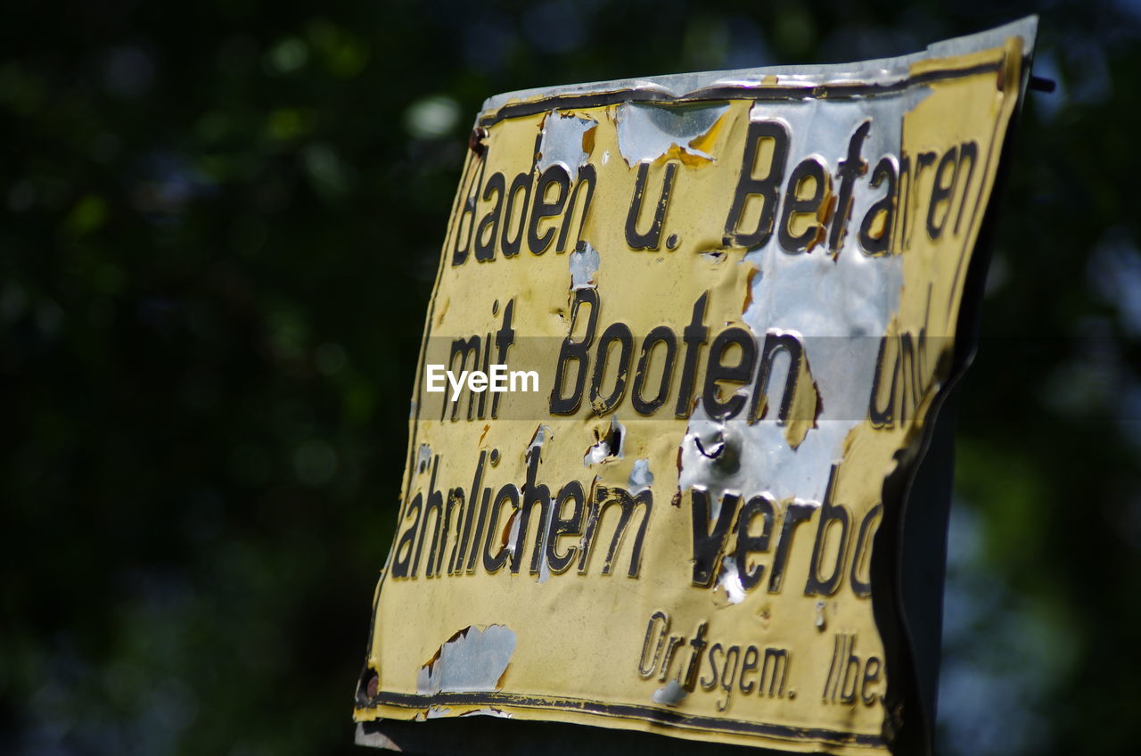 CLOSE-UP OF TEXT ON METAL SIGN