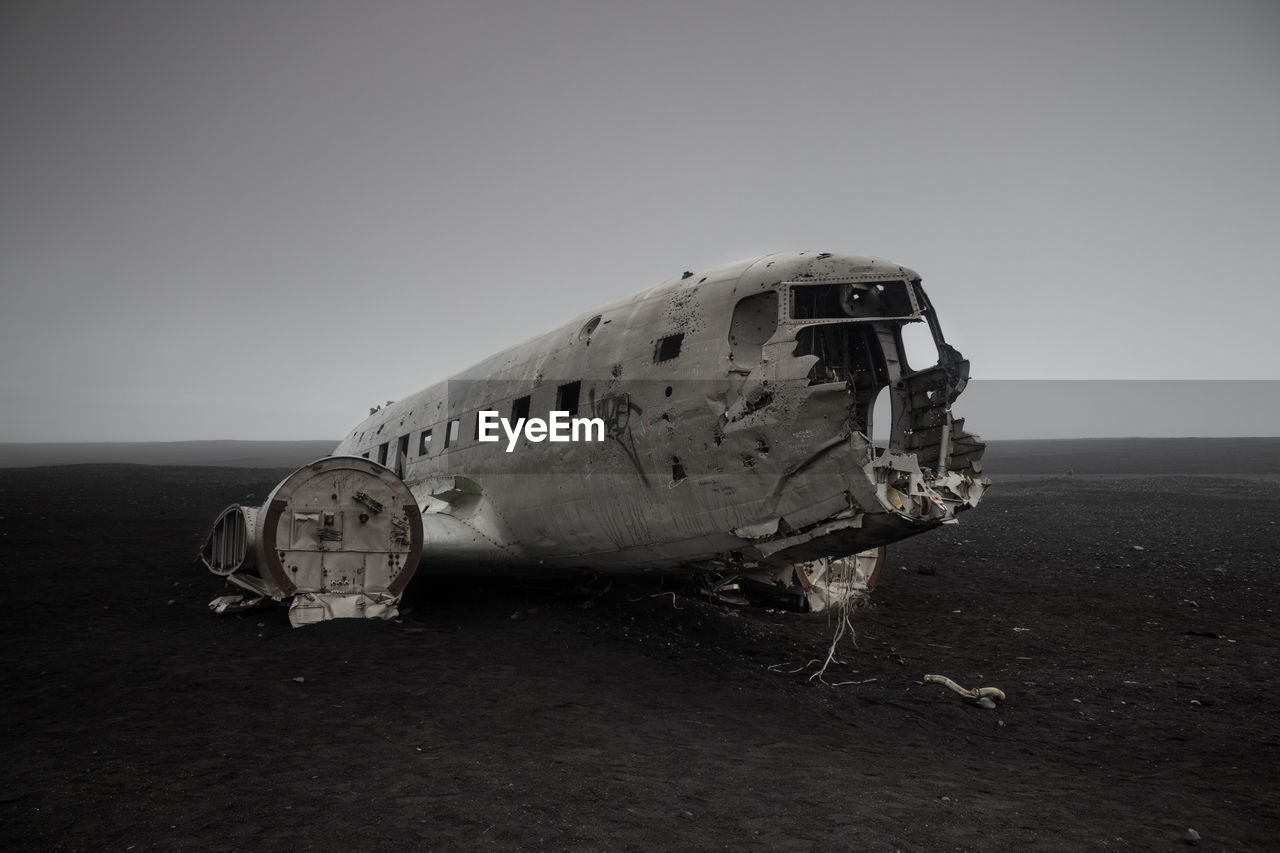 ABANDONED AIRPLANE ON SAND AT BEACH