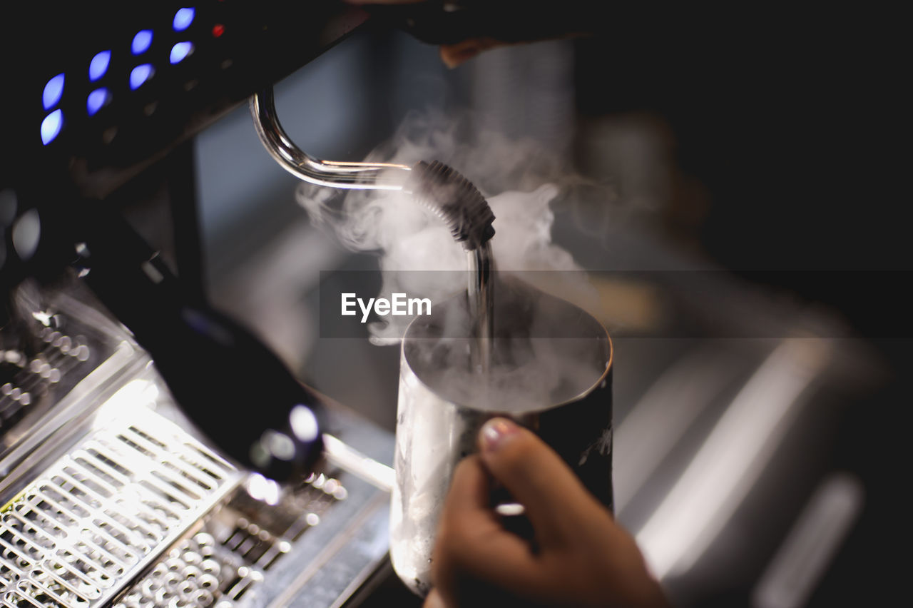 The barista is pouring the coffee mixture.