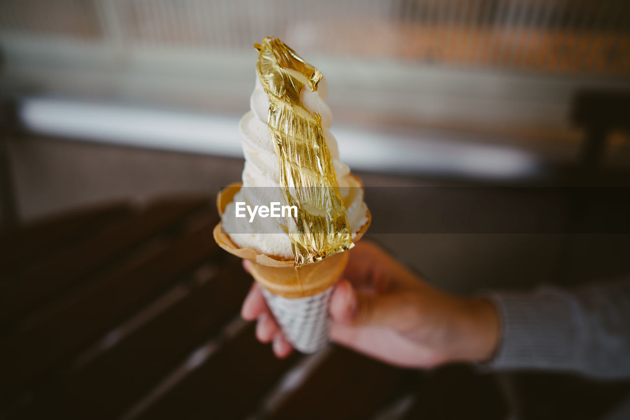 Close-up of hand holding ice cream cone