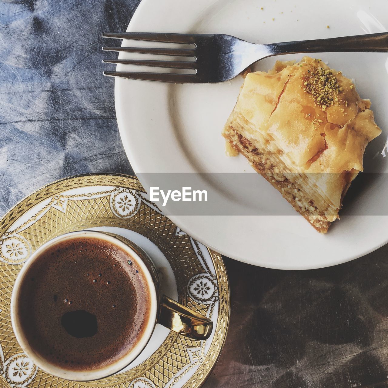 Directly above shot of black coffee and baklava on table