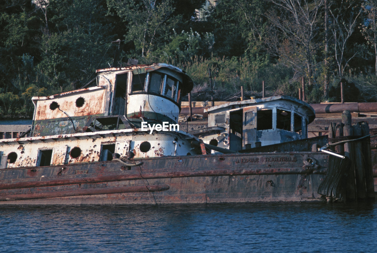 ABANDONED BOAT BY TREES