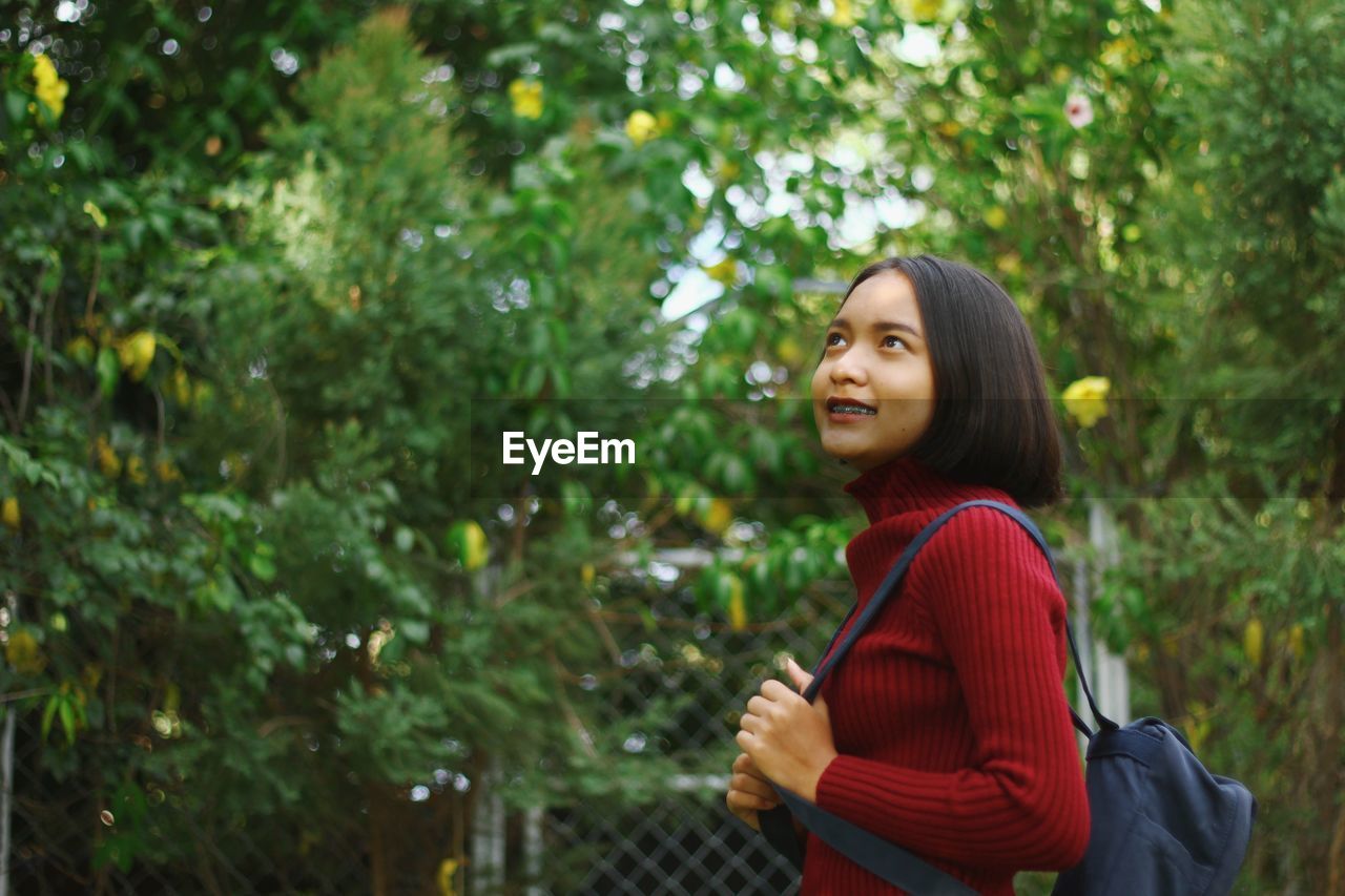 Smiling teenage girl against trees in forest