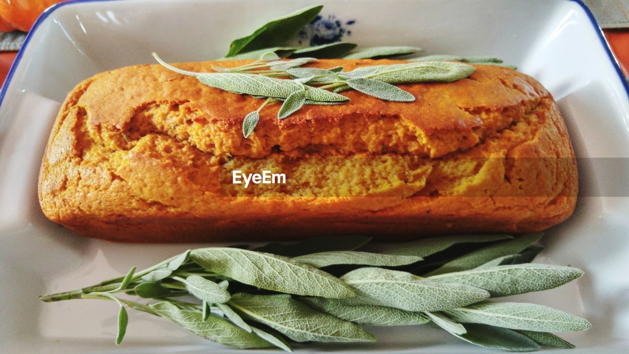 High angle view of pumpkin bread by sages in plate on table