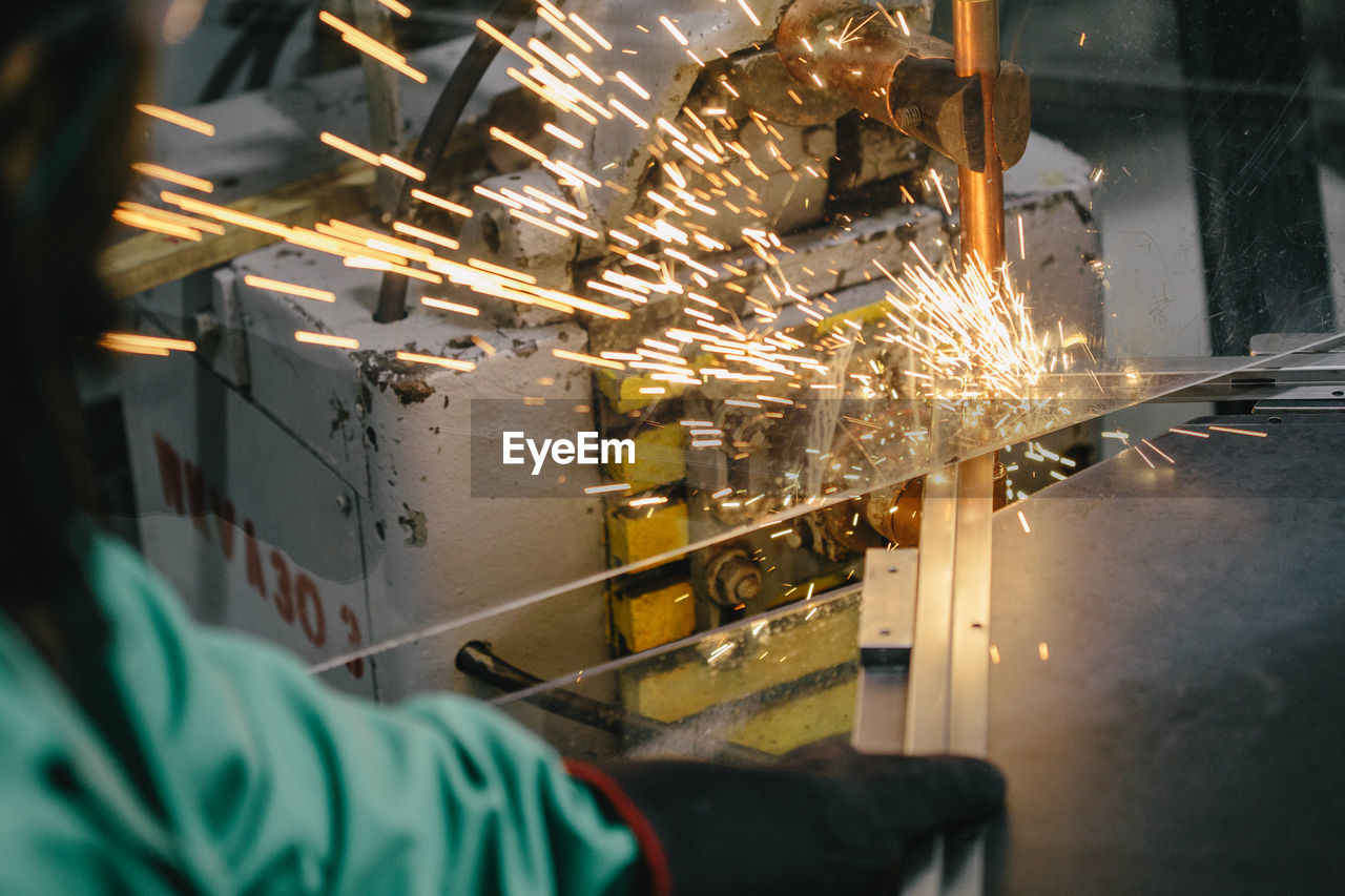 Cropped hand of male welder welding at factory