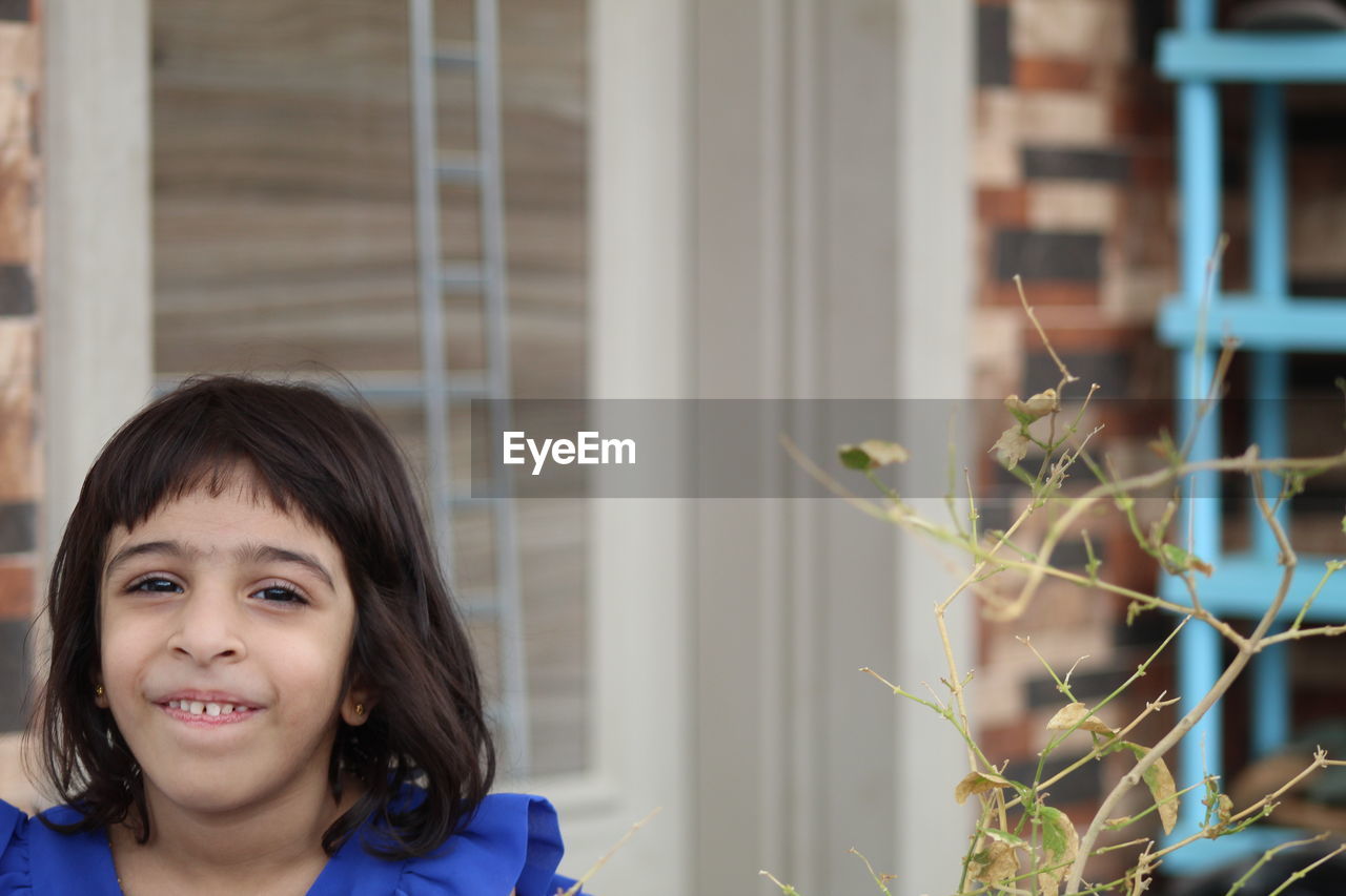 PORTRAIT OF A SMILING GIRL OUTDOORS