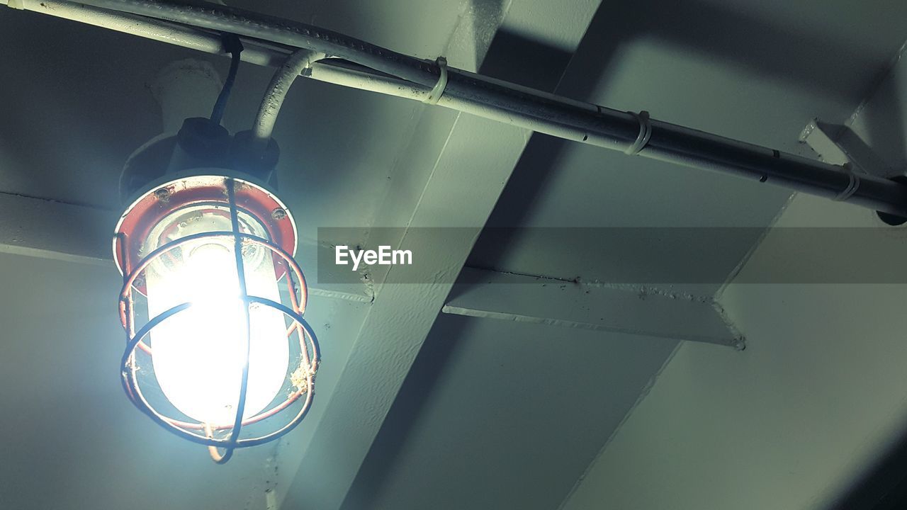 LOW ANGLE VIEW OF LIGHT BULB HANGING FROM CEILING