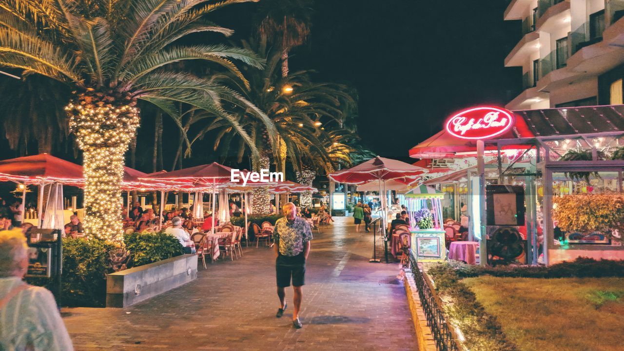 PEOPLE WALKING ON STREET AT NIGHT IN CITY