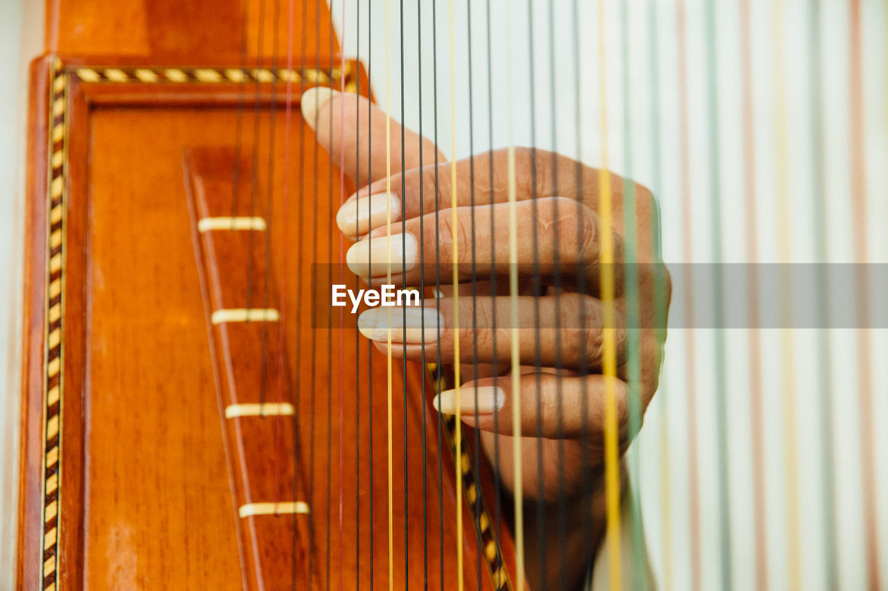 Close-up of hand playing harp