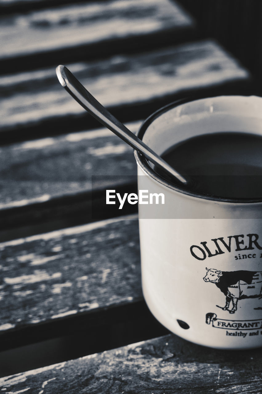 CLOSE-UP OF COFFEE IN CUP ON TABLE AGAINST WALL