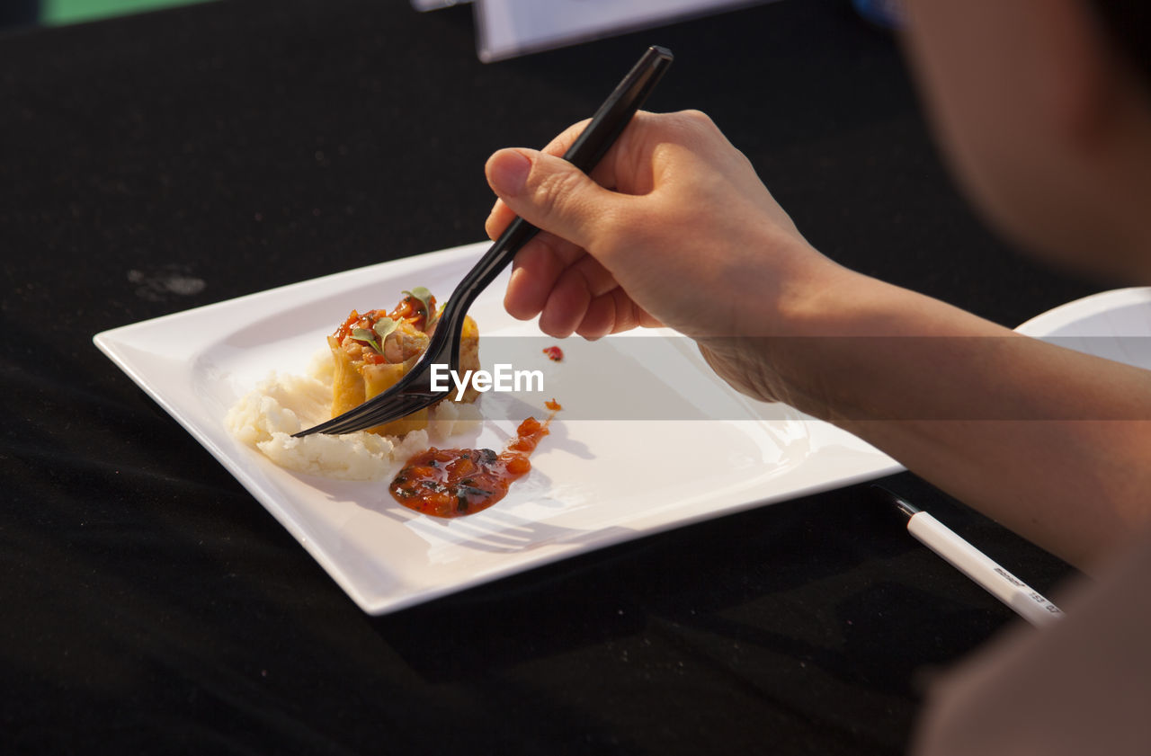 Cropped image of person having food served on table