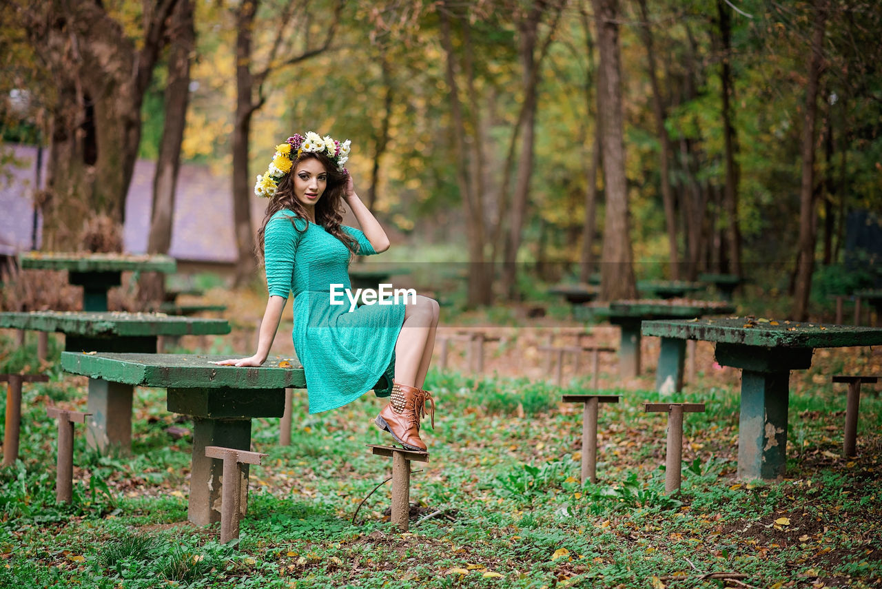 Portrait of woman sitting on table in forest