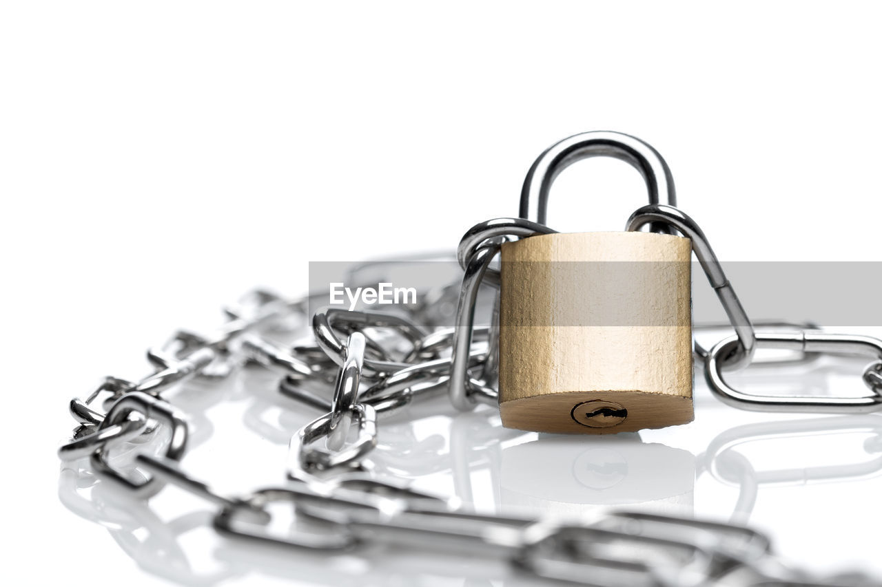 Close-up of padlock and chain on white background