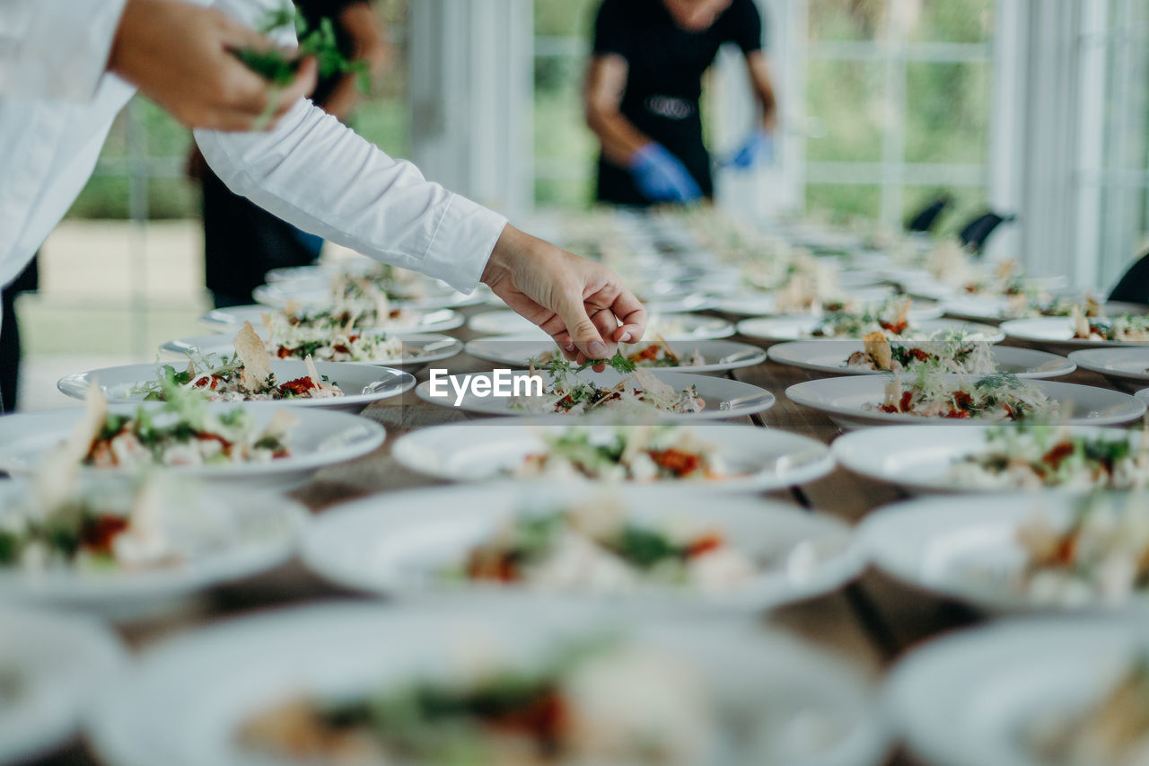 Midsection of man serving food in plates on table at wedding ceremony