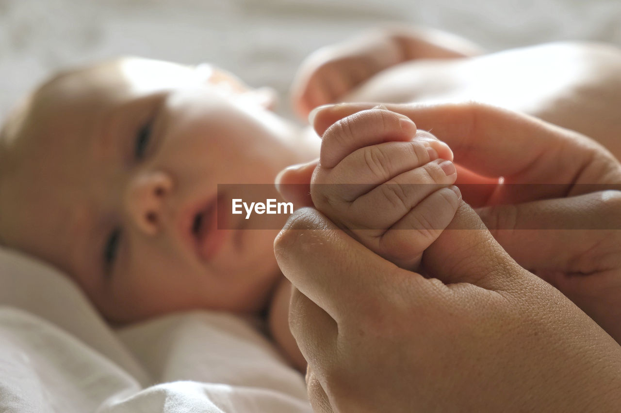 Baby hand in mother hands. newborn baby tiny fingers, close up. maternity, family, birth. infant. 