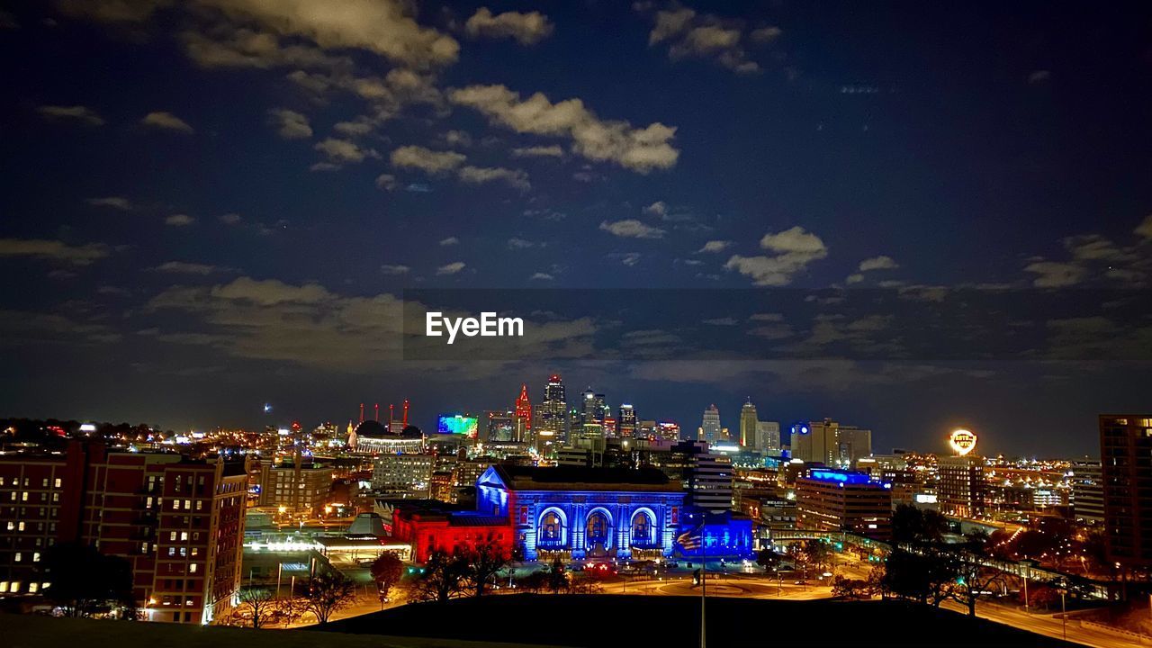 HIGH ANGLE VIEW OF ILLUMINATED BUILDINGS AGAINST SKY