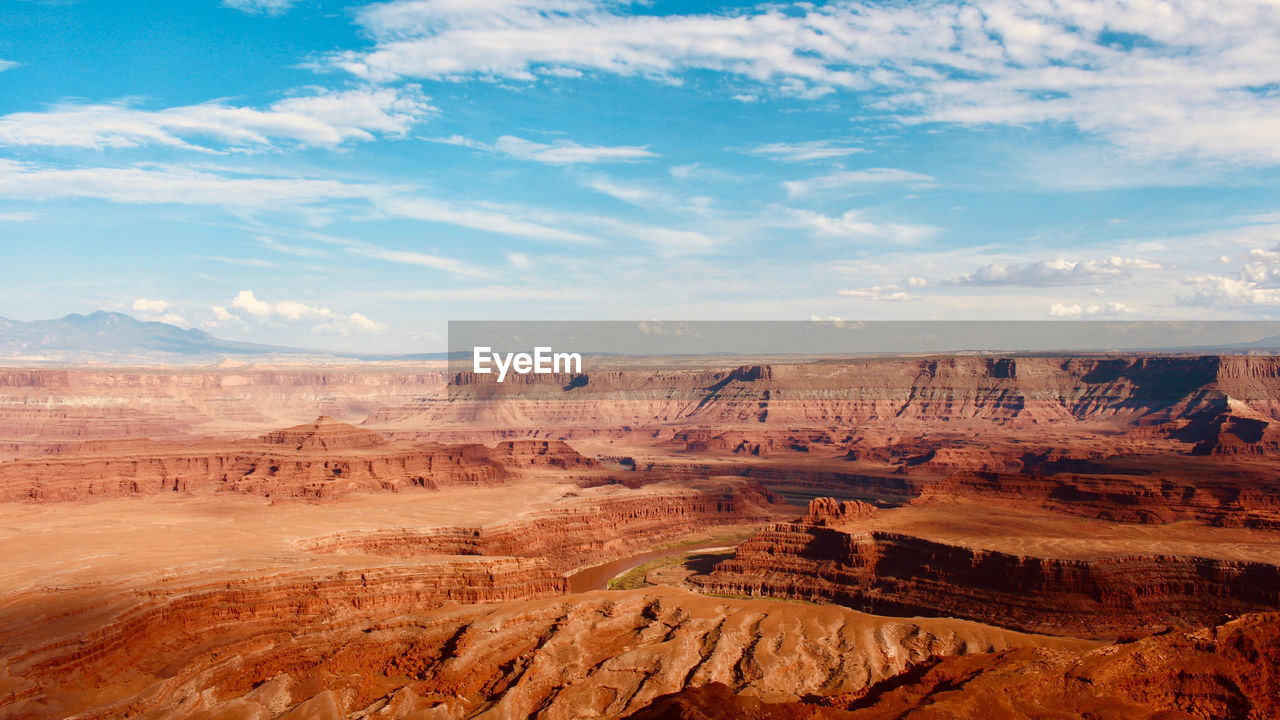 Scenic view of desert against cloudy sky