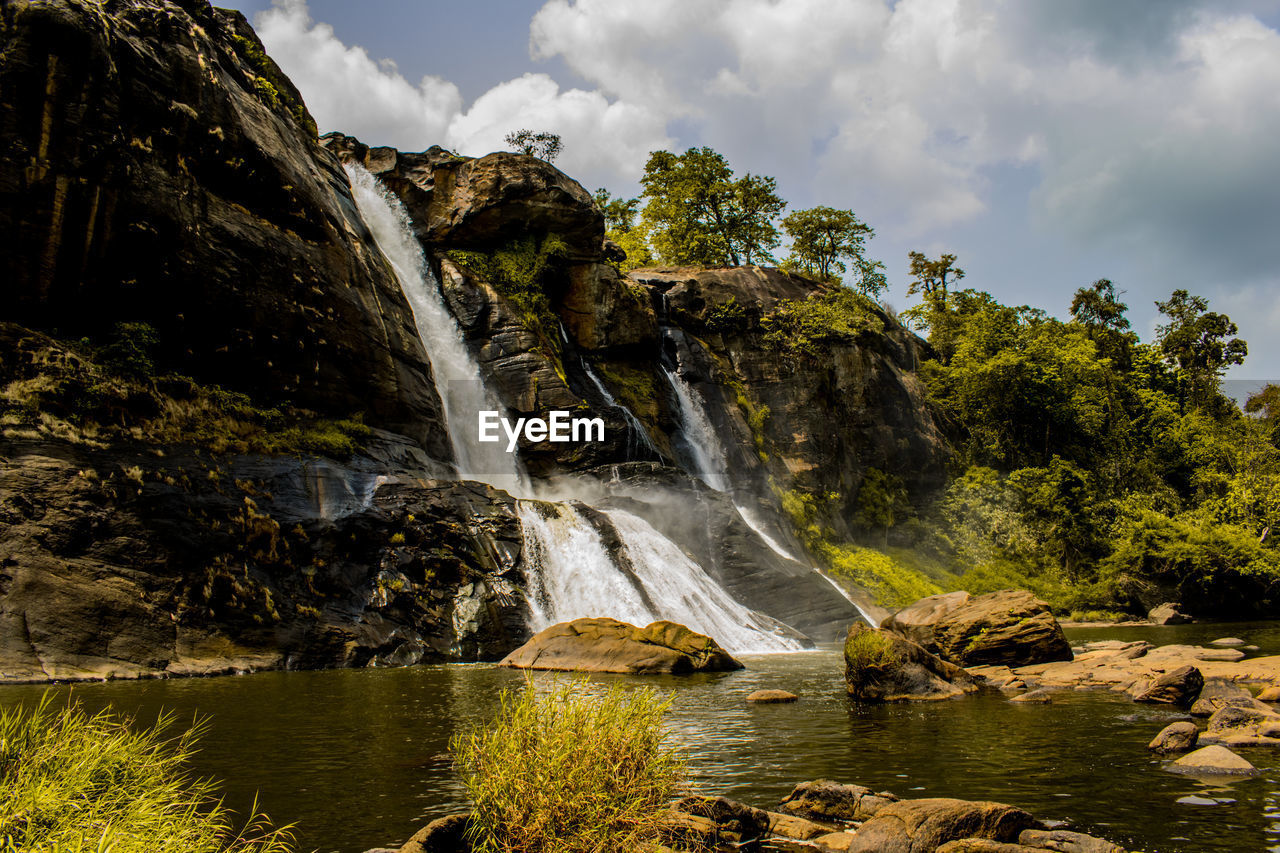 Scenic view of waterfall against sky