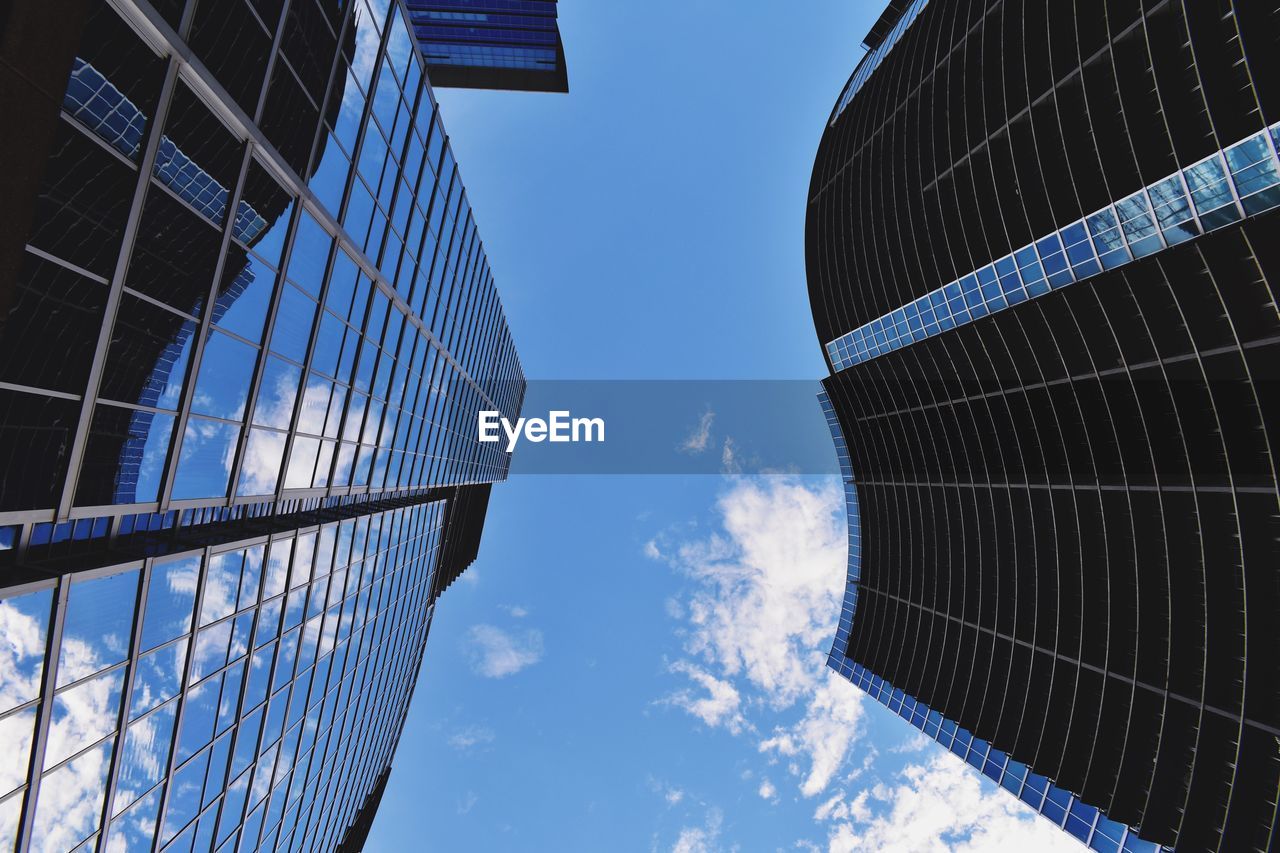 Low angle view of skyscrapers against blue sky