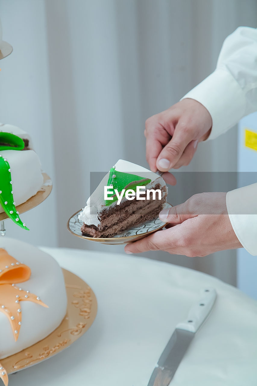 Cropped image of person holding cake in plate