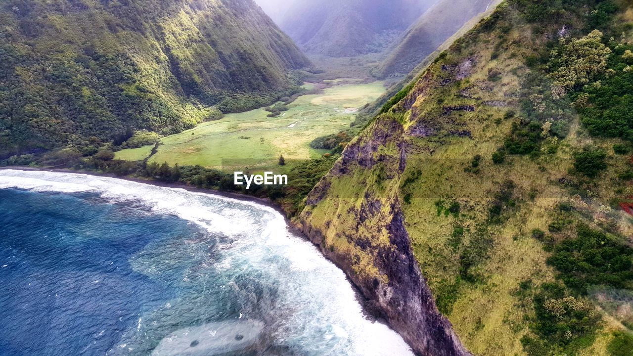 SCENIC VIEW OF WATERFALL ON MOUNTAIN