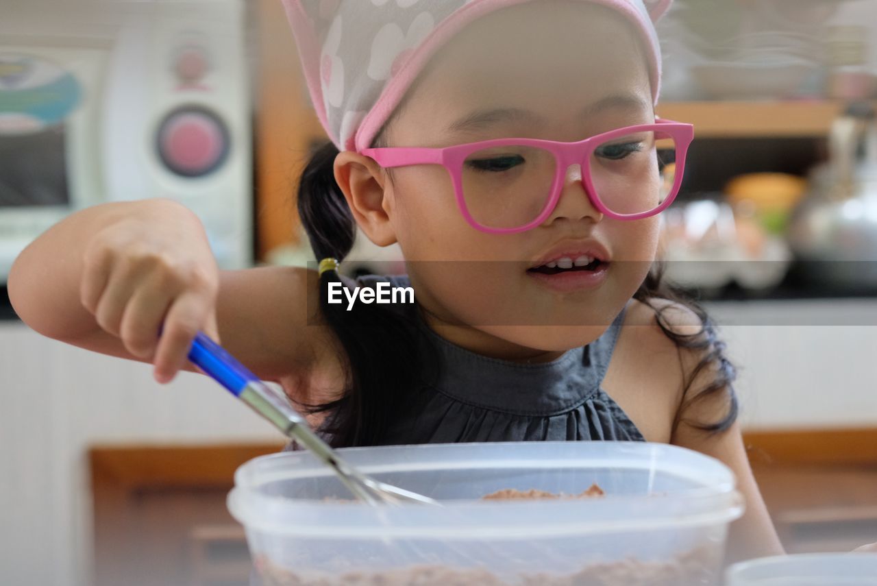 Close-up of cute girl preparing food on table